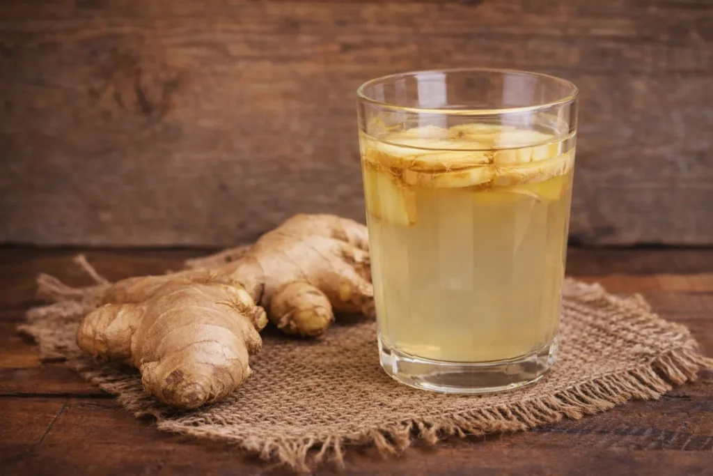Glass of ginger water with fresh ginger root showing ginger water benefits for digestion, immunity and weight loss